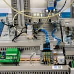 Close-up of industrial equipment showcasing electronic wiring and sensors in a manufacturing setup.