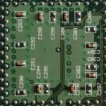 Detailed close-up of a green circuit board featuring microchips and labeled components.